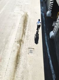 High angle view of man cycling on road by building