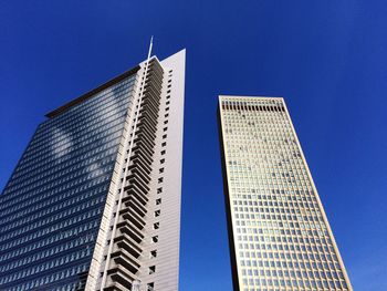 Low angle view of modern buildings against clear blue sky