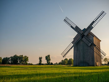 Traditional windmill on field against sky