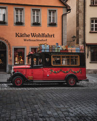 Red vintage car on street against building