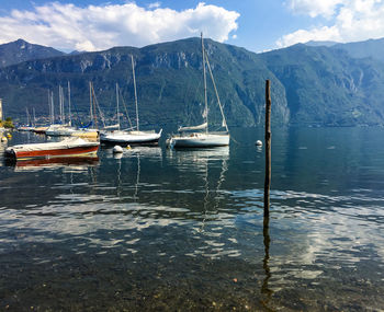 Boats moored in lake against mountain range