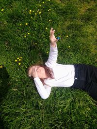 High angle view of young girl laying  on grassy field