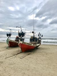 Ship moored on beach against sky