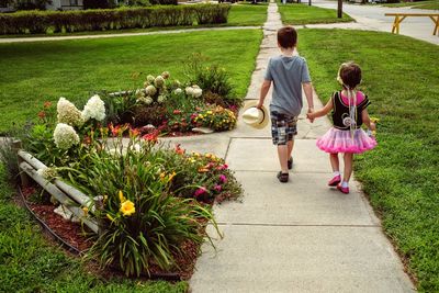 Sister and brother walking on footpath