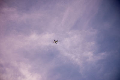 Low angle view of silhouette airplane against sky