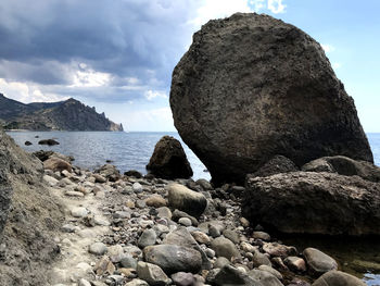 Rock formation on beach against sky