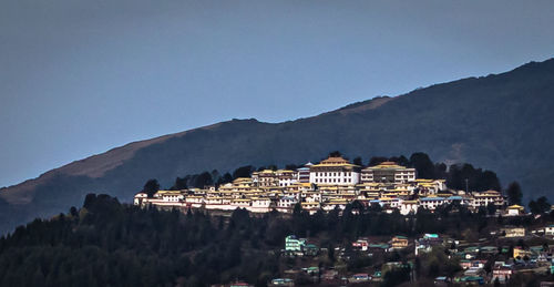 Buildings in city against clear sky at dusk