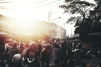 Crowd in city against sky