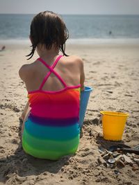 Rear view of boy sitting on beach