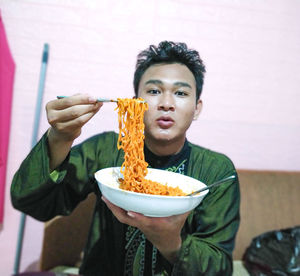 Portrait of young man eating food