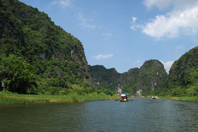 Scenic view of river amidst mountains against sky