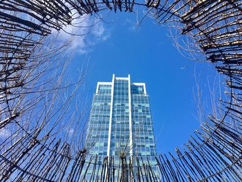 Low angle view of modern buildings against blue sky