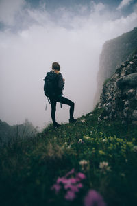 Low angle view of man walking on mountain against sky