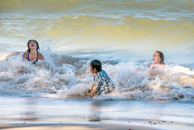 Wild waves wash over a group of active kids as they play in lake michigan usa