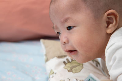 Close-up portrait of cute baby lying on bed