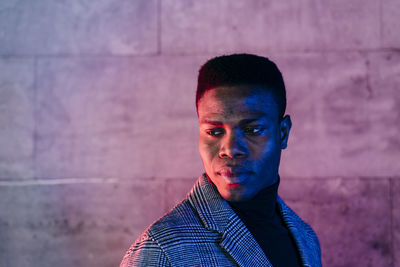 Portrait of young man against wall