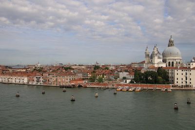 View of buildings in city against cloudy sky