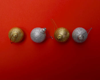 Directly above shot of christmas ornaments on red background
