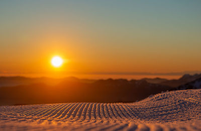Freshly groomed ski slope at sunset