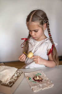 Girl doing craft wrapping for festive gifts with stamp printing technique