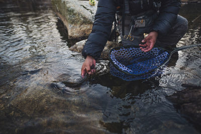 A man released a brook trout during a cold morning fishing in maine