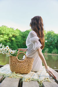 Rear view of woman sitting on table