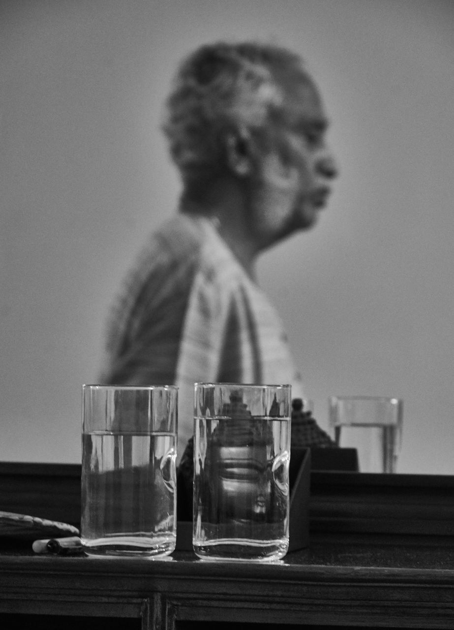 one person, table, glass, drinking glass, focus on foreground, household equipment, drink, food and drink, refreshment, childhood, real people, water, women, indoors, glass - material, transparent, container, females, drinking