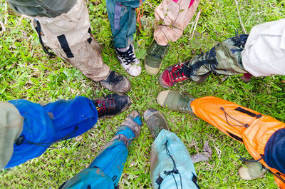 Low section of male friends standing on grassy field