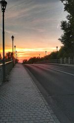 Empty road against sky at sunset