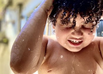 Close-up of shirtless boy splashing water