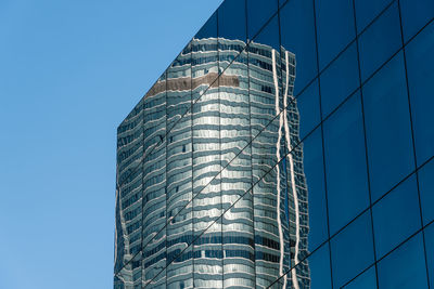 Low angle view of skyscraper against clear blue sky