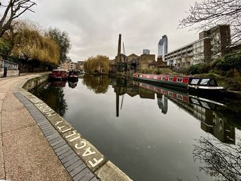 Bridge over river in city against sky