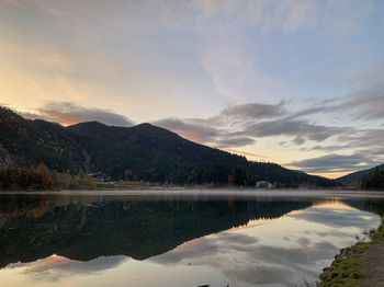 Scenic view of lake and mountains against sky during sunset