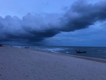 Scenic view of beach against sky at dusk