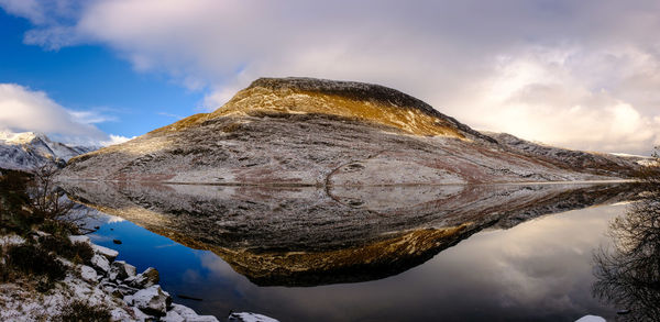 Reflection of snowy mountains in a lake in snowdonia national park, north wales