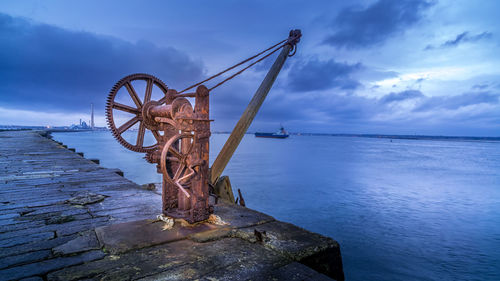 Ferris wheel by sea against sky