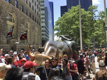 People on street against buildings in city