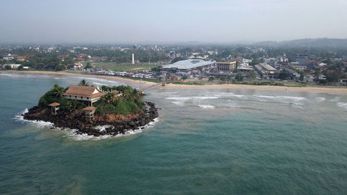 High angle view of townscape by sea against sky