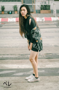 Young woman standing on road