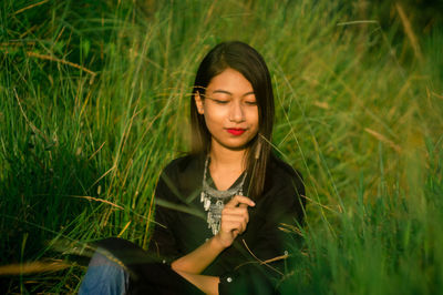 Young woman sitting amidst grass