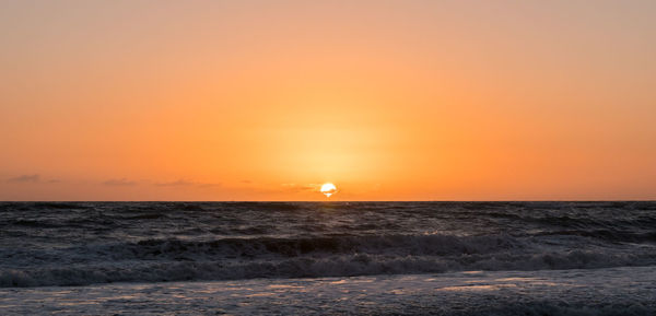 Scenic view of sea against orange sky