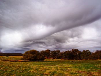 Scenic view of grassy field against cloudy sky