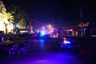 People on illuminated street at night