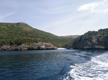 Scenic view of sea and mountains against sky