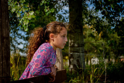 Side view of girl looking away at farm