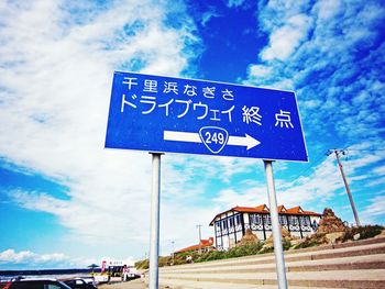 Low angle view of road sign against cloudy sky