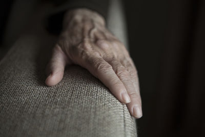 Close-up of person hand on armrest