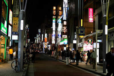 People walking on street in city at night