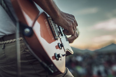 Cropped hand of man playing guitar