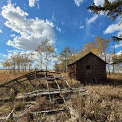 Abandoned house on field against sky